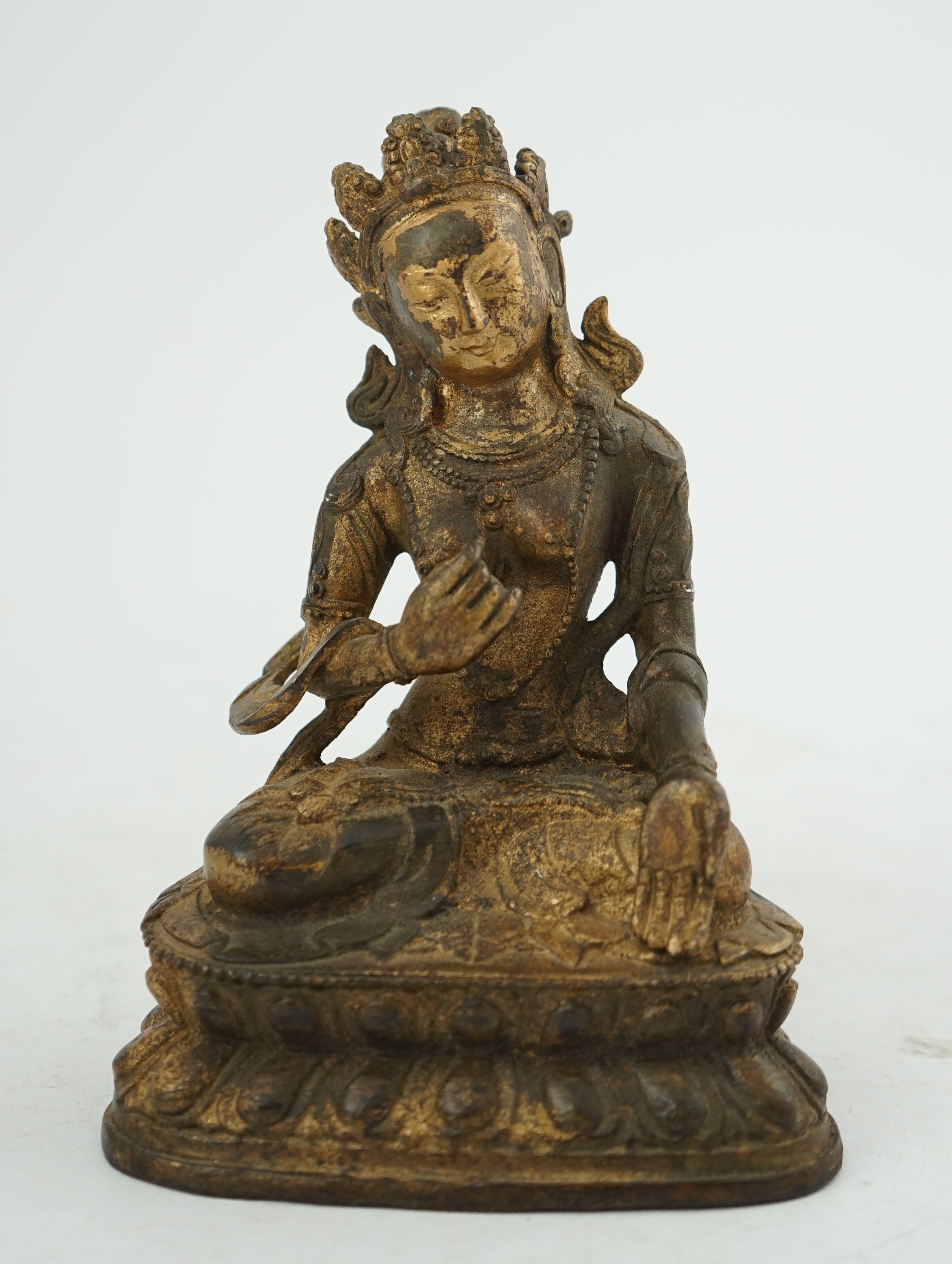 A Tibetan gilt bronze figure of seated Tara, on a double lotus throne, 16.5cm high. Condition - good